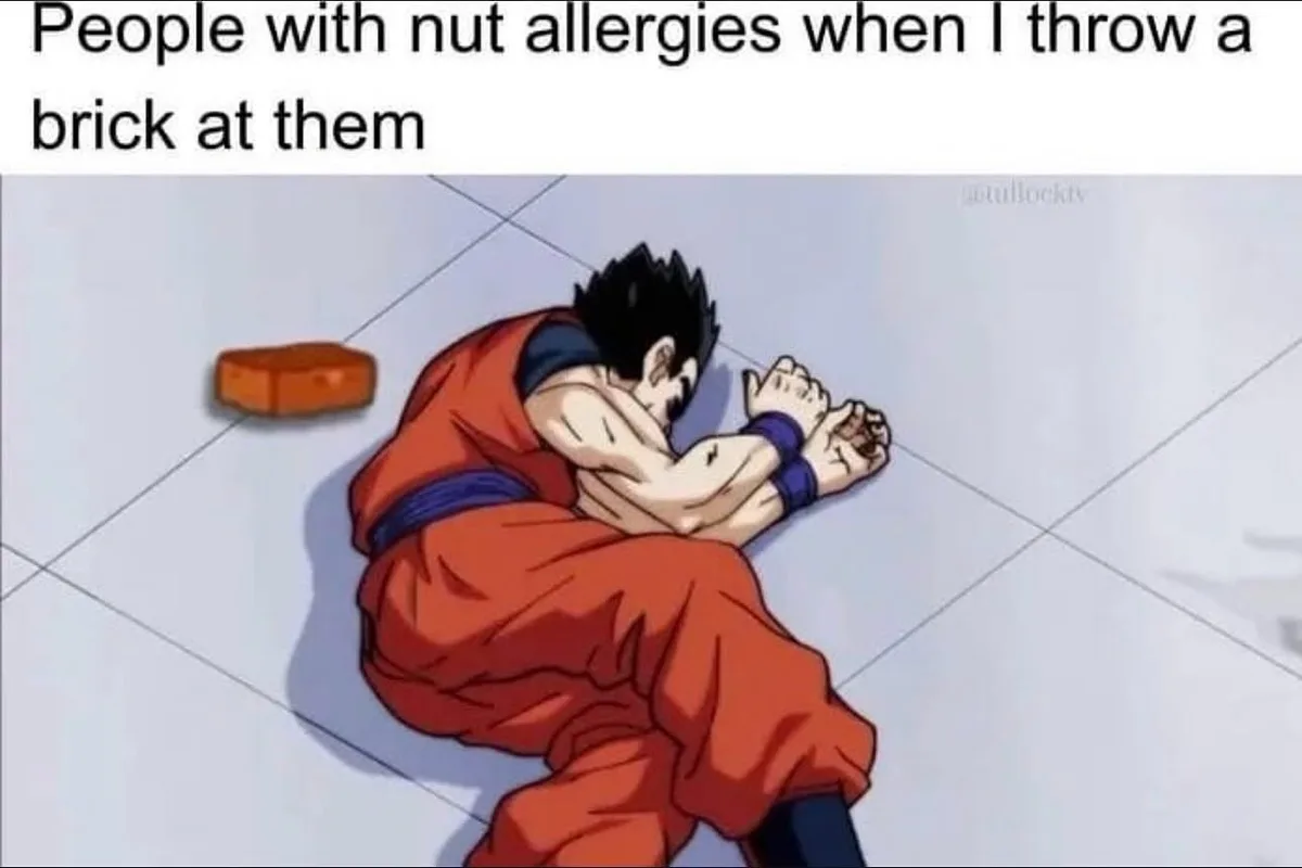 An anime character in an orange gi is curled up on a tiled floor, clutching his hands to his face in distress, while a brick…