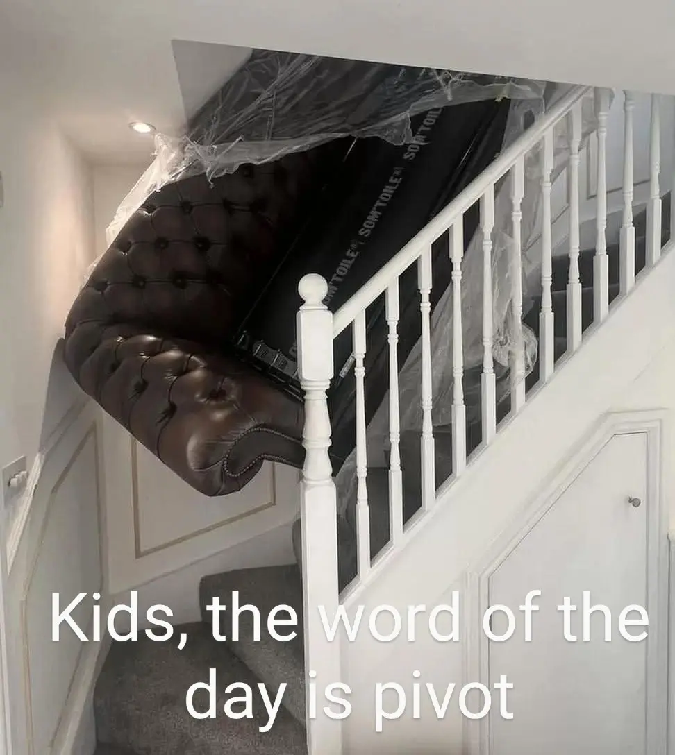 A brown tufted leather armchair is awkwardly wedged upside down in the corner of a white staircase, partially wrapped in…