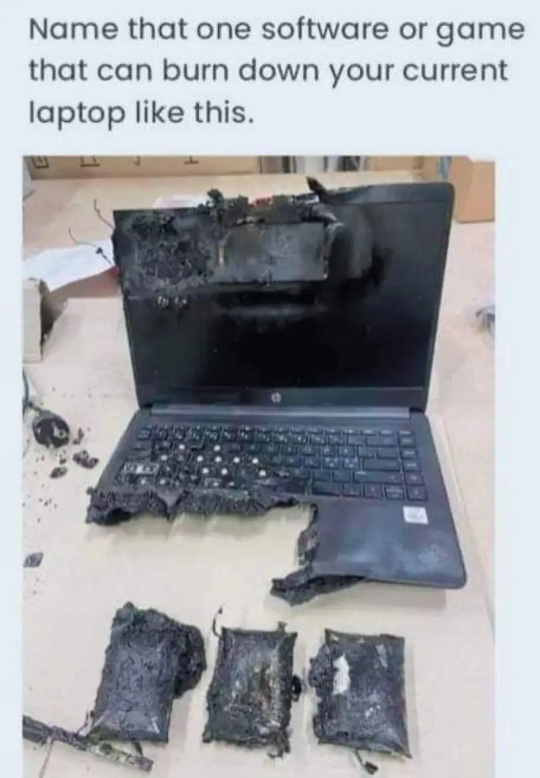 A severely burnt laptop with melted plastic, charred keyboard, and shattered screen sits on a table, with three melted…