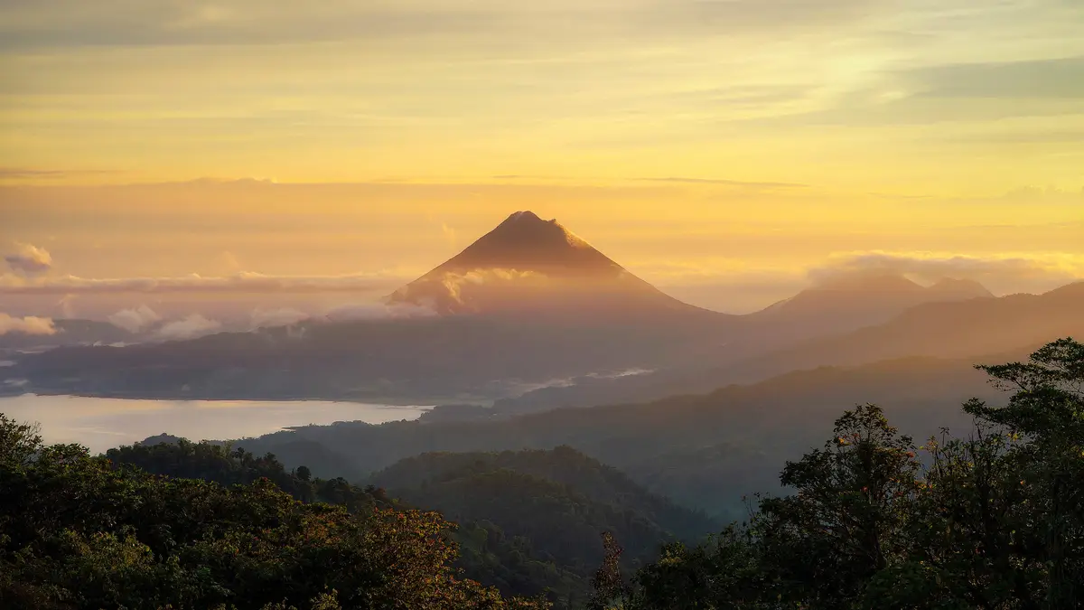 In the misty Costa Rican rainforest, a young and majestic Arenal Volcano rises high. Only 7,000 years old, it's a rapid…
