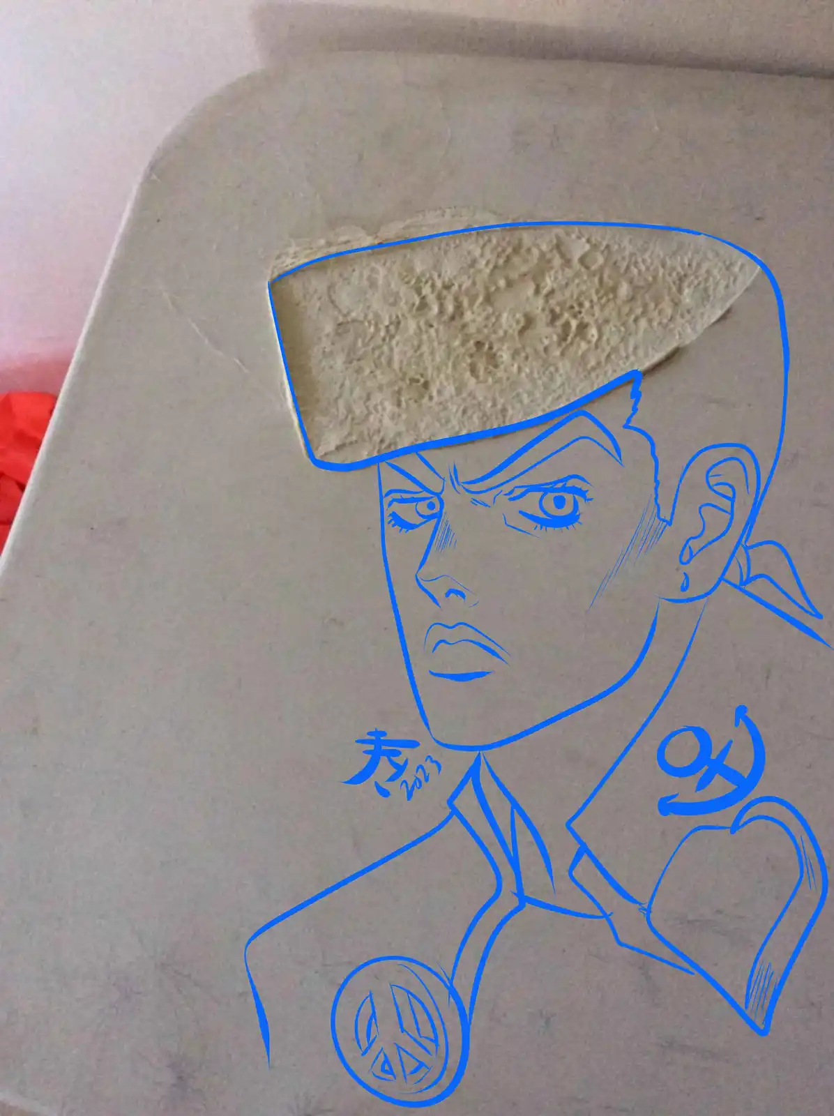 A blue outline drawing of a stylized anime character with a stern expression, drawn on a white toilet lid. The character…