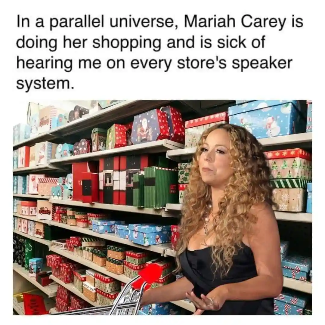 A woman with long curly hair, wearing a black dress and pushing a shopping cart, stands in a store aisle filled with…