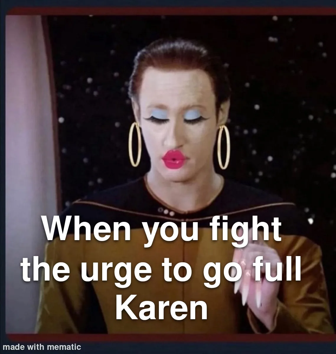 A woman with red hair, heavy makeup, and large gold hoop earrings wears a Starfleet uniform and looks down with a pensive…