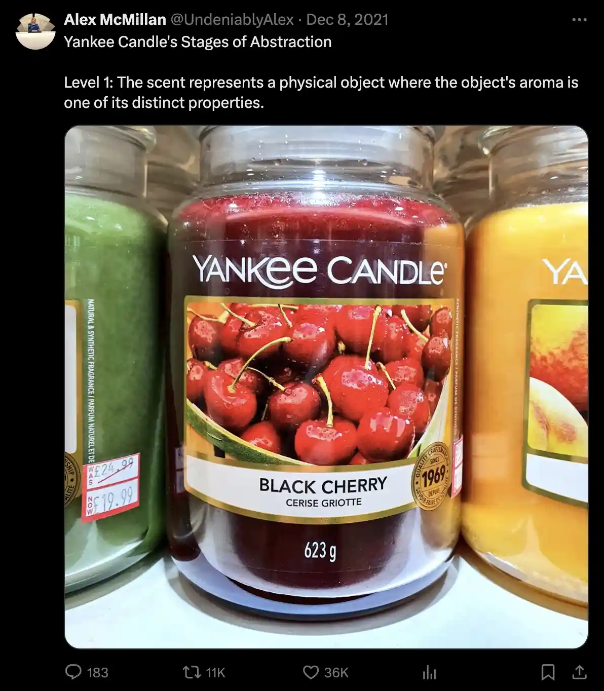 A close-up photo shows a Yankee Candle jar labeled 'Black Cherry' with an image of glossy red cherries on its label, sitting…