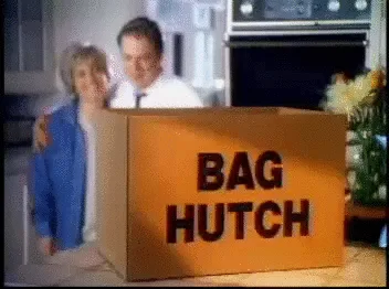 A six-panel sequence from a vintage TV commercial shows a smiling couple behind a cardboard box labeled 'BAG HUTCH'. A blue…