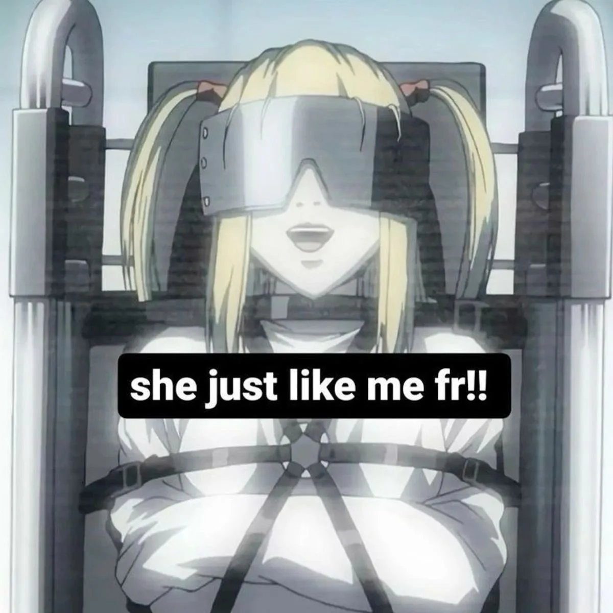 An anime character with blonde pigtails is strapped into a metal chair with her arms bound and wearing a blindfold, looking…