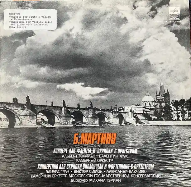 A vintage black-and-white album cover featuring a scenic view of a stone bridge over water with historic buildings under a…