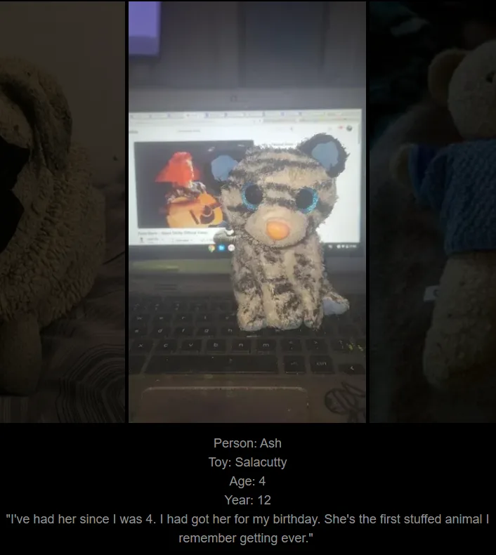 A plush tiger toy with blue ears and large eyes sits on a laptop keyboard, with a YouTube video playing on the screen behind…