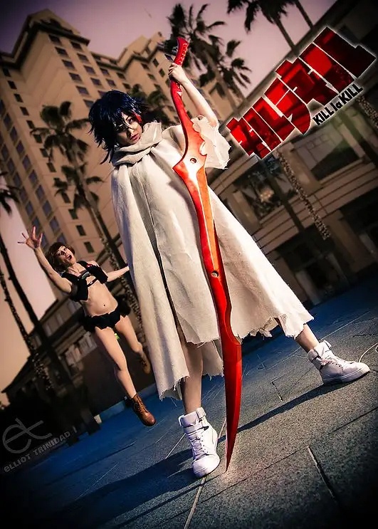 A cosplayer dressed as the anime character Satsuki Kiryuin from 'Kill la Kill' holds a giant red scissor-like weapon while…