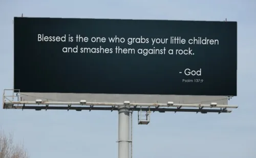 A large outdoor billboard displays a dark background with white text that reads 'Blessed is the one who grabs your little…
