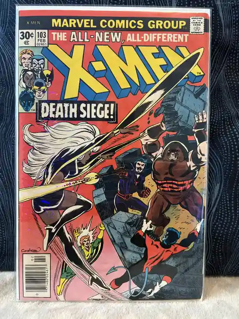 A vintage X-Men comic book cover from Marvel Comics Group, issue #103, featuring a dynamic action scene with multiple…
