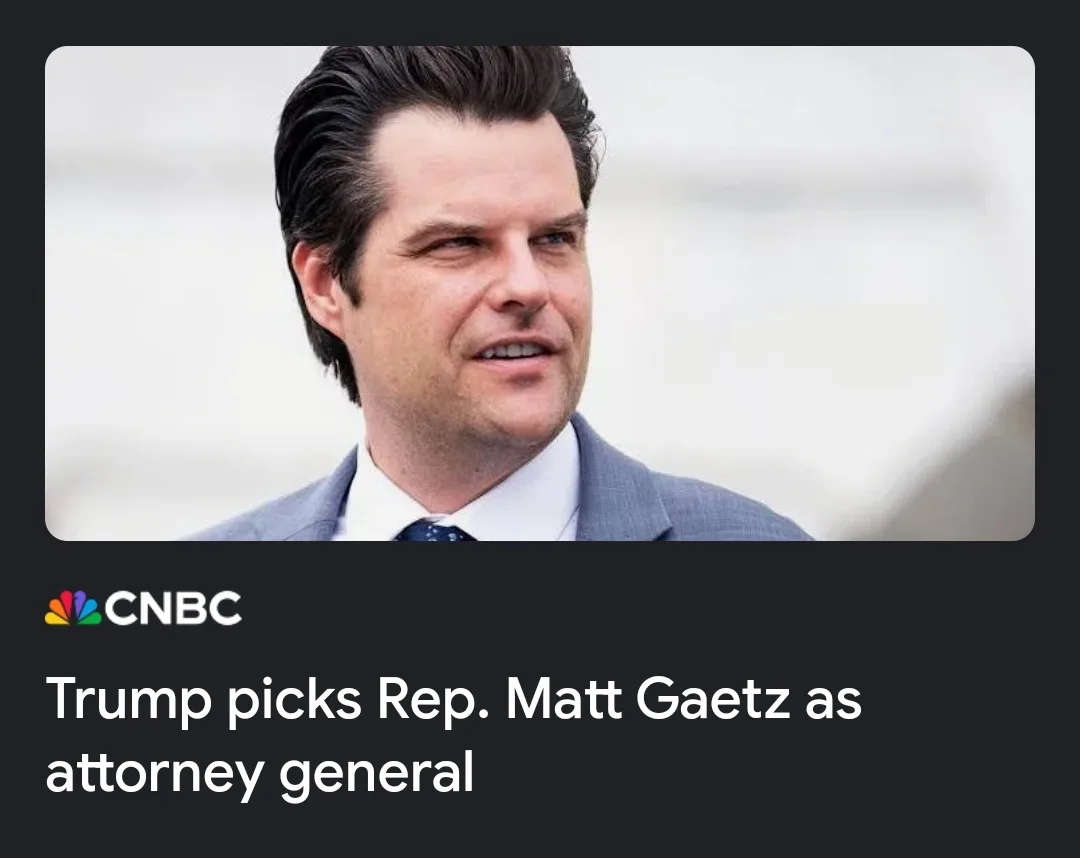 A close-up photo of Matt Gaetz, a man with dark hair and a slight smirk, wearing a gray suit, white shirt, and patterned…