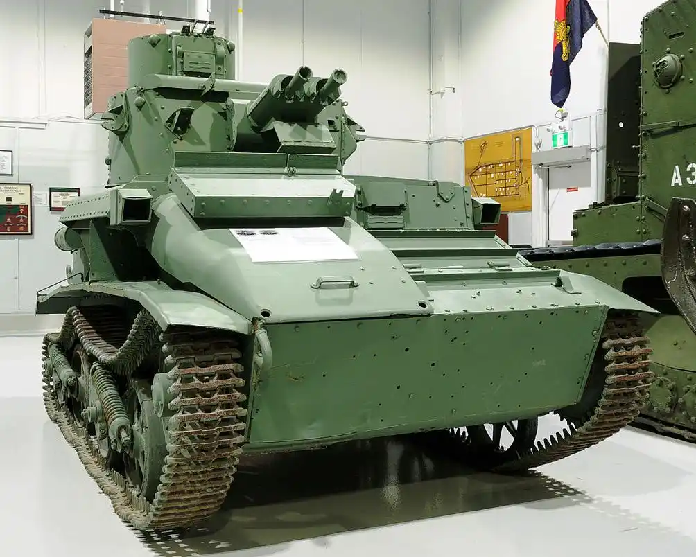 a green military tank with multiple mounted guns is displayed indoors, likely in a museum, with overlaid text reading 'this…