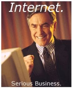 A man in a suit and tie, smiling broadly while looking at a computer monitor, with the text 'Internet.' at the top and…