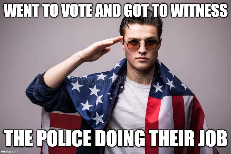 A man with slicked-back hair, wearing sunglasses and an American flag draped over his shoulders, salutes with his right…