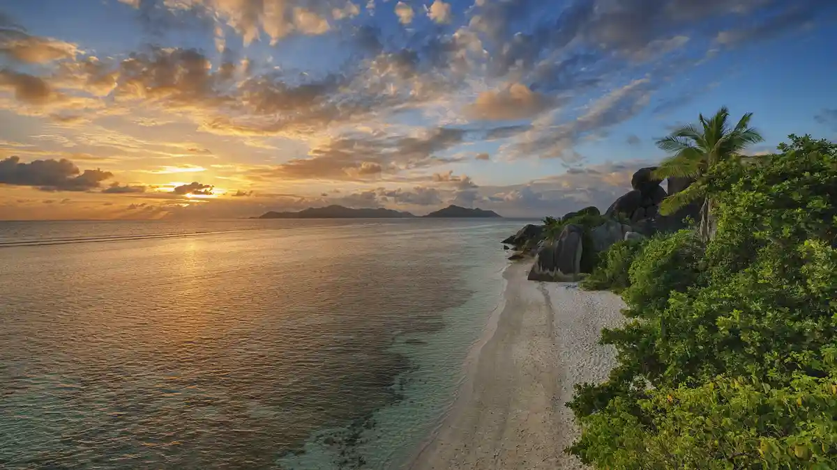The sandy coast of La Digue, Seychelles, stretches across the image, a picturesque beach on the Indian Ocean islands…