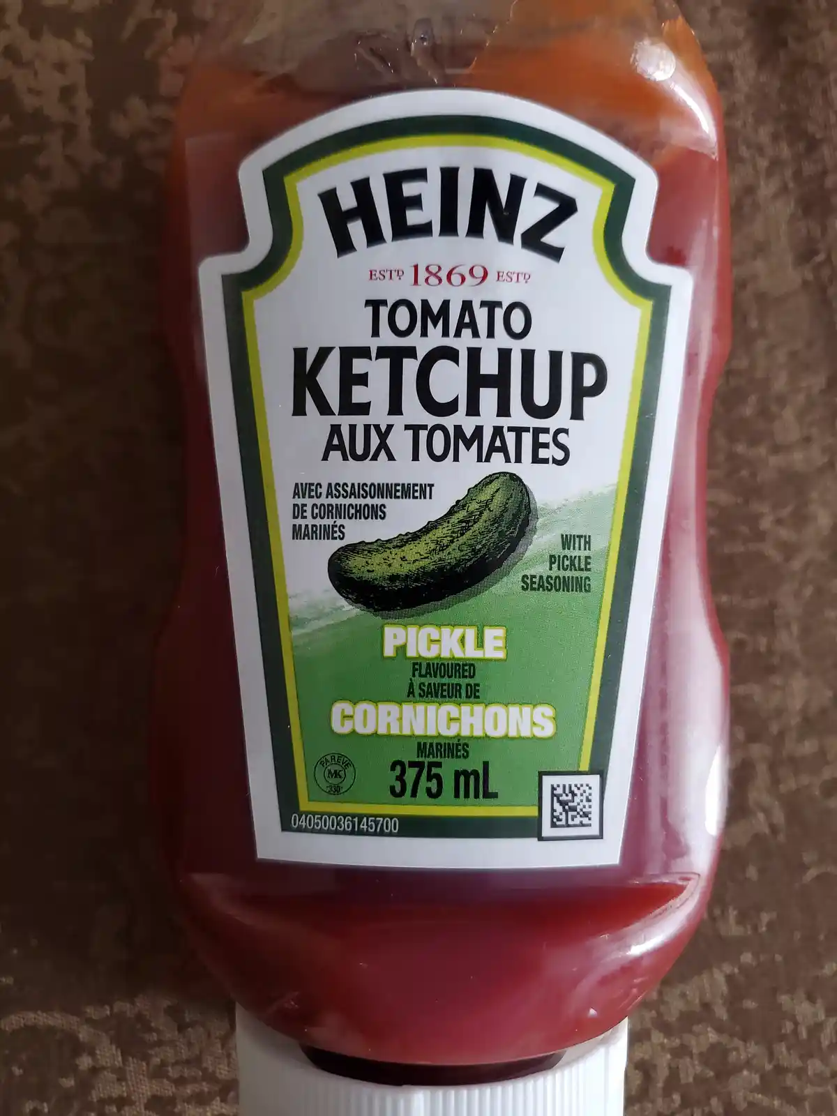 A close-up photo of a Heinz ketchup bottle with a label that has been altered to read 'Tomato Ketchup Aux Tomates' and…