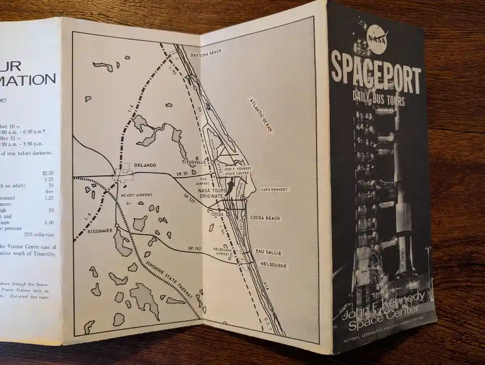 A vintage NASA pamphlet titled 'SPACEPORT DAILY BUS TOURS' for the John F. Kennedy Space Center, open to a map showing…
