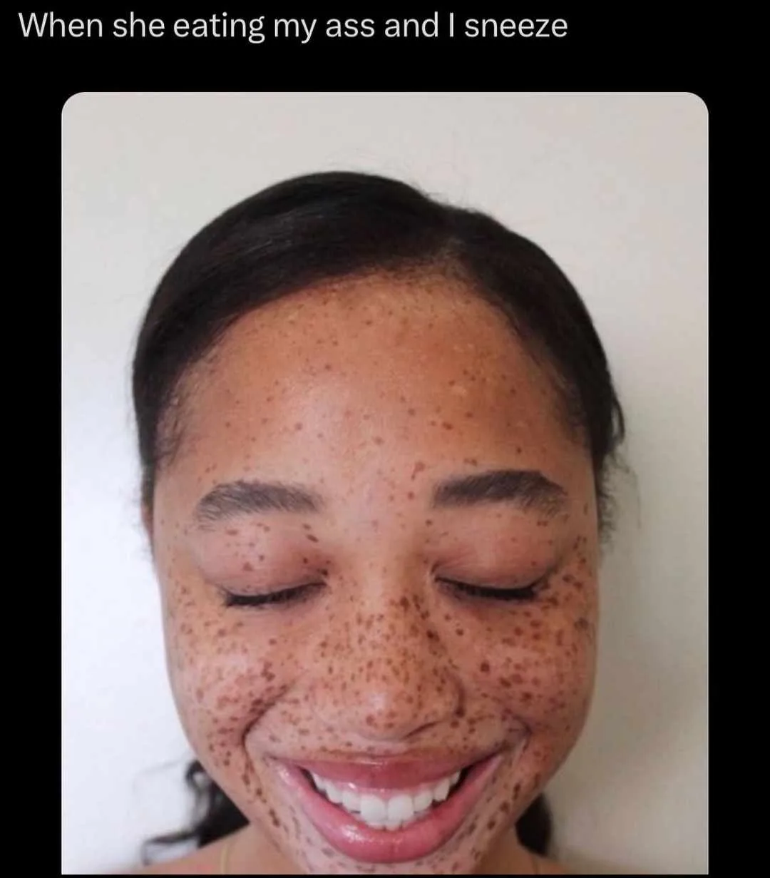 A close-up photo of a woman with dark hair pulled back, smiling broadly with her eyes closed. Her face is covered in…