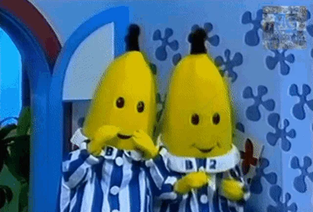 Two banana-costumed characters, labeled B1 and B2, stand side-by-side in blue-and-white striped pajamas against a blue…