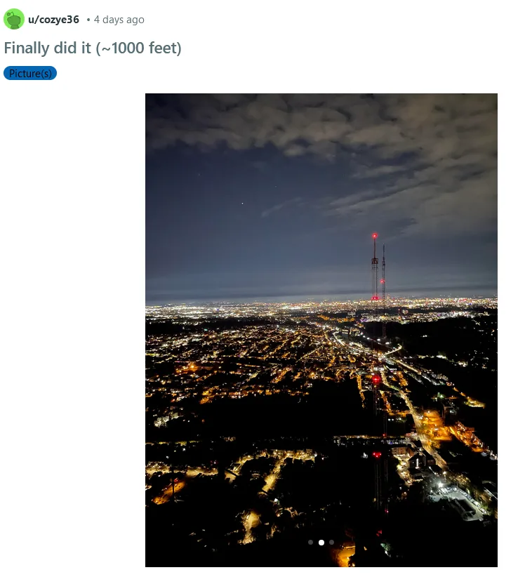 A nighttime photo taken from a high vantage point, looking down on a sprawling cityscape illuminated by countless lights…