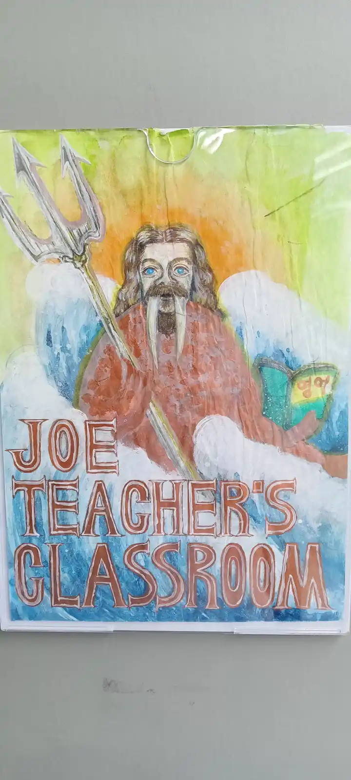 A hand-drawn classroom poster depicts a mythological sea god with a trident, tusks, and blue eyes, seated on waves while…