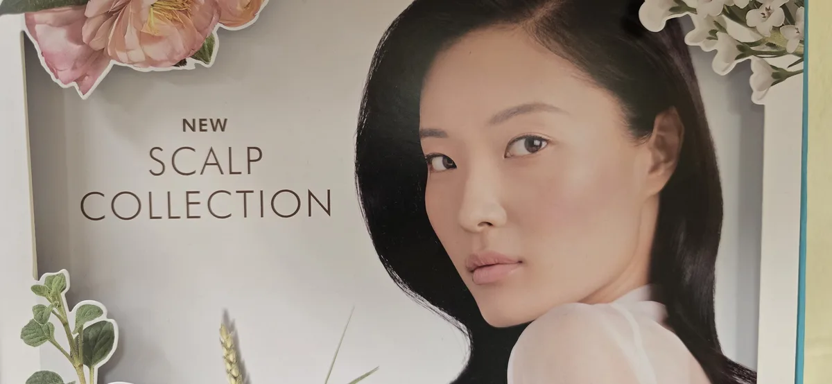 A close-up of a beauty advertisement featuring a woman with long dark hair and a serene expression, framed by pink and white…
