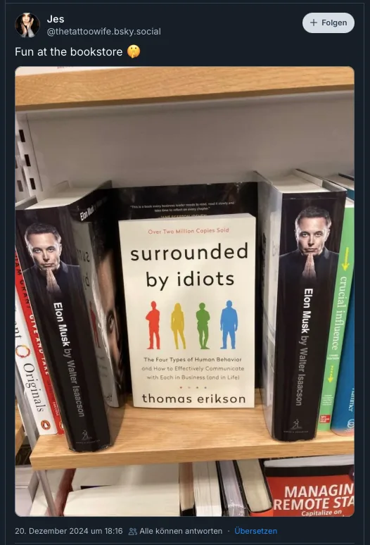 A bookshelf displays several books, including 'surrounded by idiots' by Thomas Erikson, flanked by two copies of 'Elon Musk'…