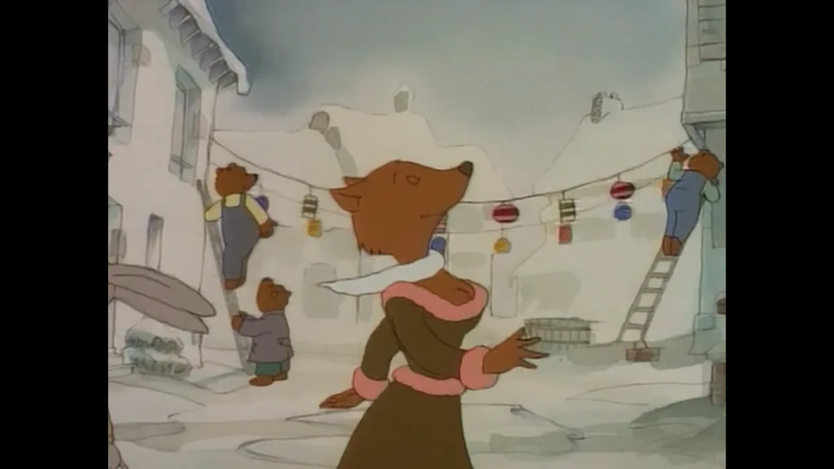 A cartoon fox in a winter coat and scarf stands in a snowy village street, looking up at a string of colorful holiday lights…