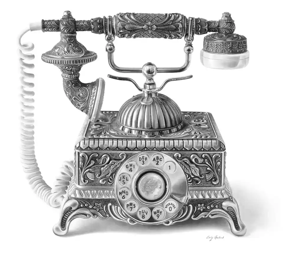 A highly detailed, ornate, silver-colored vintage rotary telephone with a coiled cord, intricate floral engravings, and a…