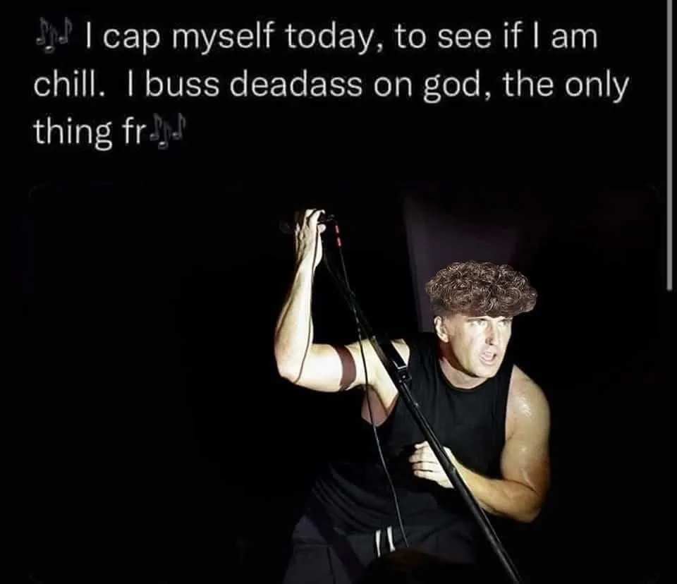A man with curly hair wearing a black tank top is holding a microphone stand in a dark setting, looking intense. White text…
