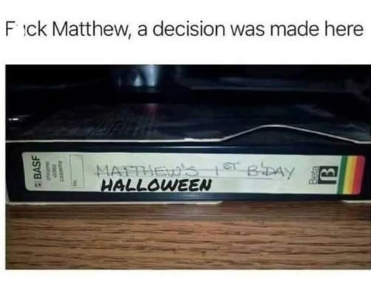 A close-up photo of a Beta video cassette tape resting on a wooden surface. The tape's label has handwritten text that reads…