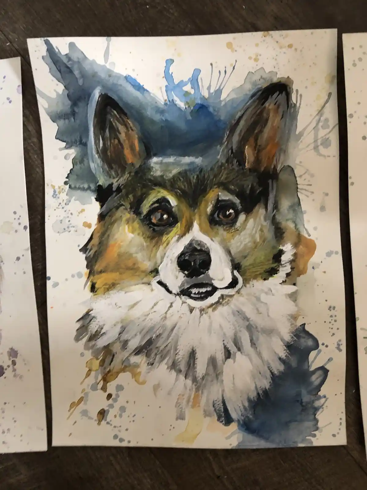 A watercolor painting of a dog's face with a fluffy white ruff, rendered in shades of brown, black, and white with blue and…