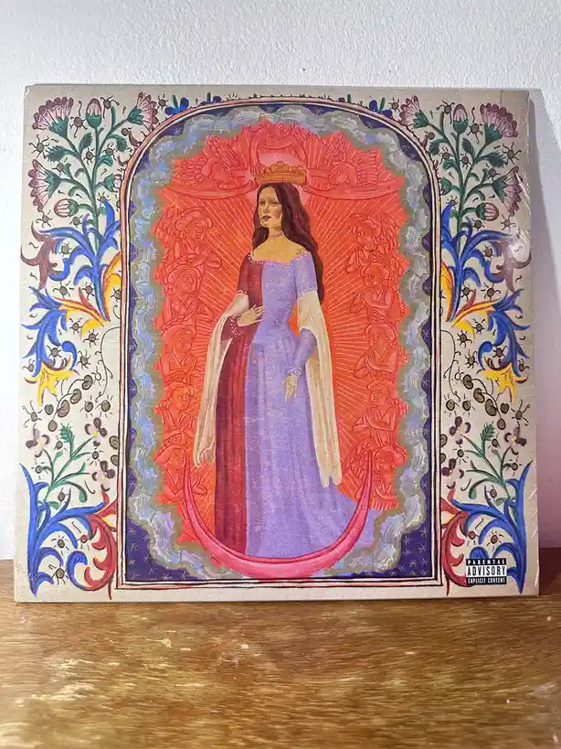 A vinyl record album cover featuring a regal, crowned woman in a purple and red gown, surrounded by angels in a stylized…