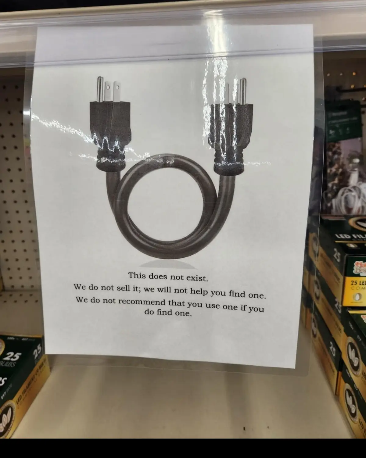 A printed sign in a retail store displays an image of a black electrical cord with both ends plugged into each other…