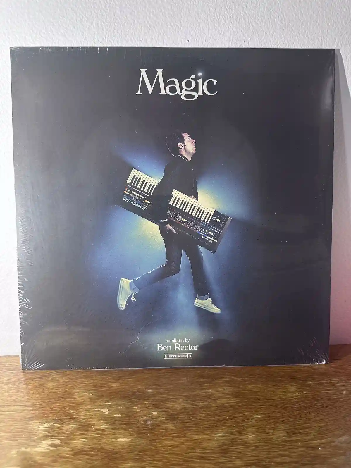 A sealed vinyl record album cover for Ben Rector's 'Magic' album, featuring a man in a dark suit and light-colored sneakers…