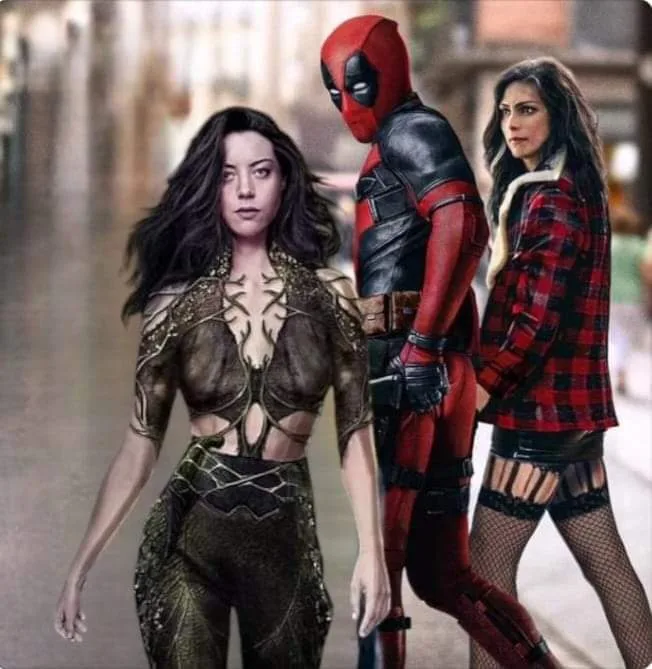 Three characters stand side-by-side on a city street: a woman in a revealing green and gold armored outfit, Deadpool in his…