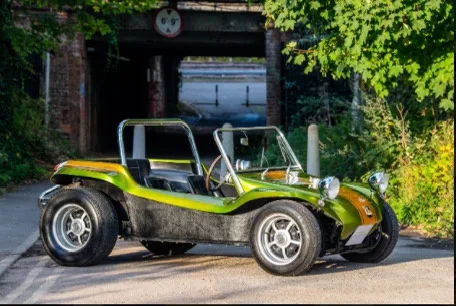 A lime green and black dune buggy with a metal roll cage is parked on a paved road under a brick archway. The vehicle has no…