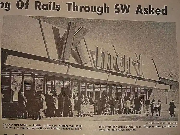 A black-and-white newspaper clipping shows a vintage K-mart store with a large sign and crowds of shoppers outside. The…