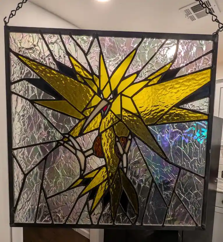 A stained glass window depicts the Pokémon Solgaleo in yellow and gold pieces, set against a textured, iridescent background…