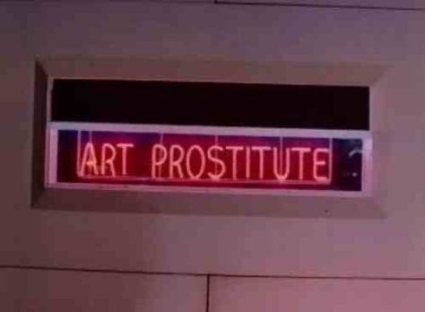 A red neon sign inside a rectangular frame mounted on a beige wall displays the words 'ART PROSTITUTE' in capital letters…