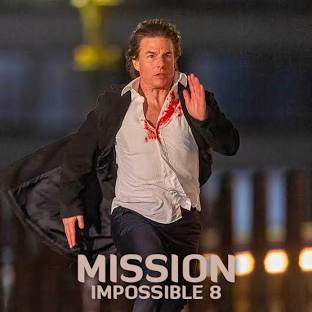 A man with dark hair, wearing a white shirt stained with red and a black jacket, is running forward with his right hand…