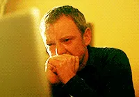 A six-panel sequence shows a man in a dark shirt progressively covering his face with his hands while looking at a laptop…