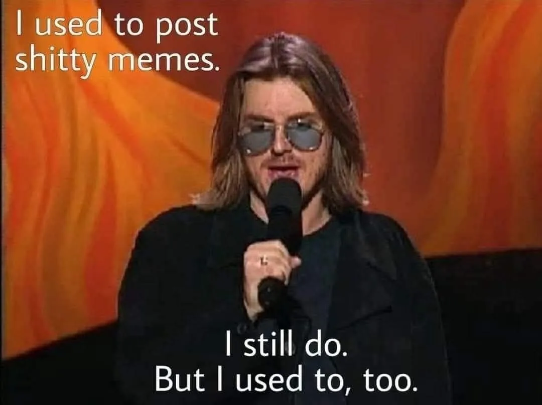 A man with long hair and sunglasses holds a microphone on stage against an orange backdrop. White text overlaid on the image…