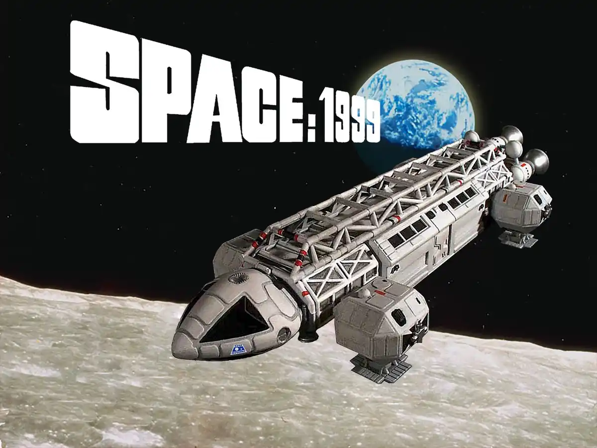 A gray, angular spaceship with a lattice-like structure and multiple spherical engines flies over a cratered moon surface…