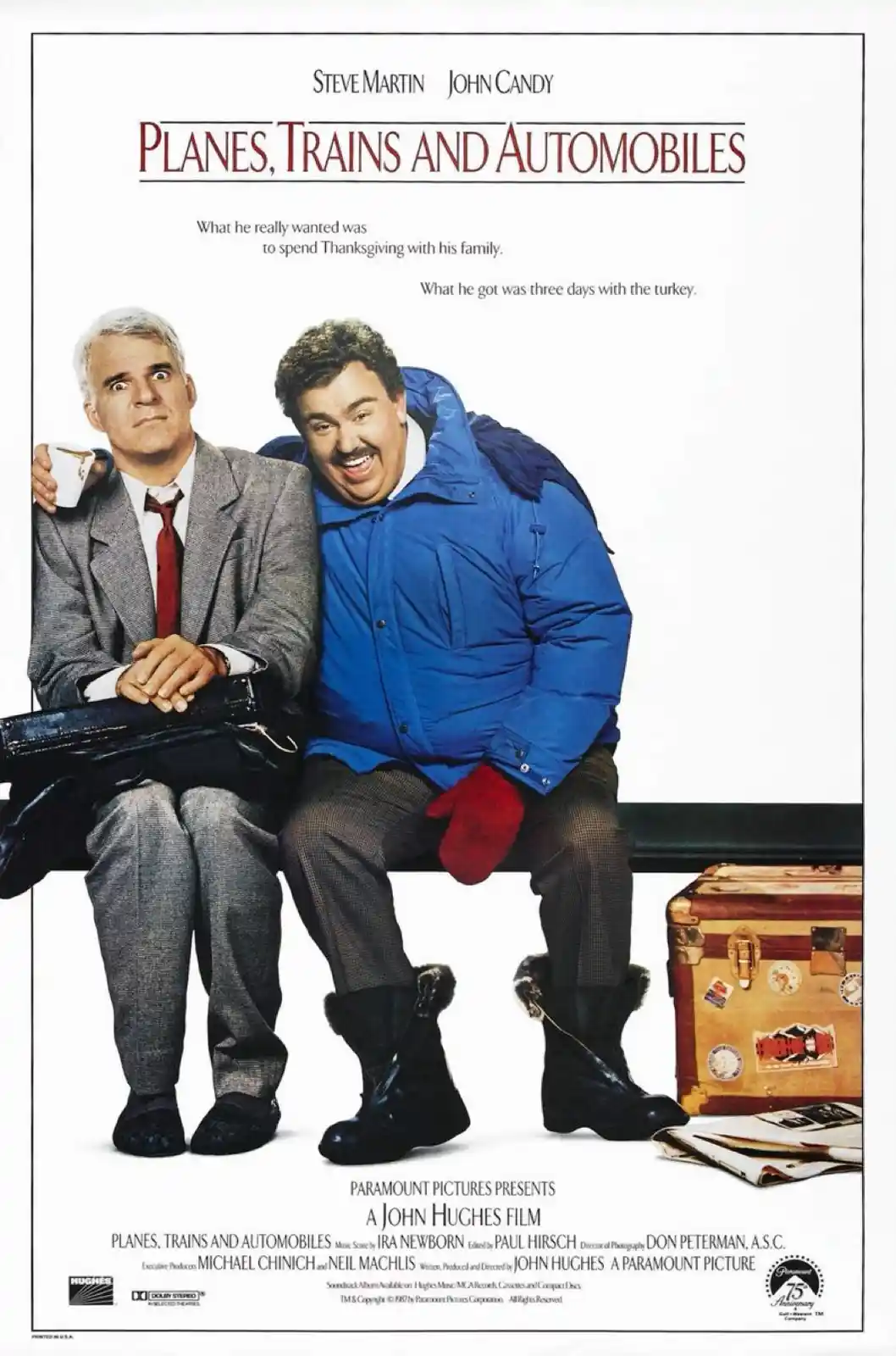 A movie poster for 'Planes, Trains and Automobiles' featuring Steve Martin and John Candy sitting on a bench. Martin looks…