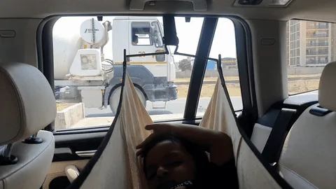 A child is shown in a hammock suspended between car seats, appearing to be sleeping or resting. The image is split into two…