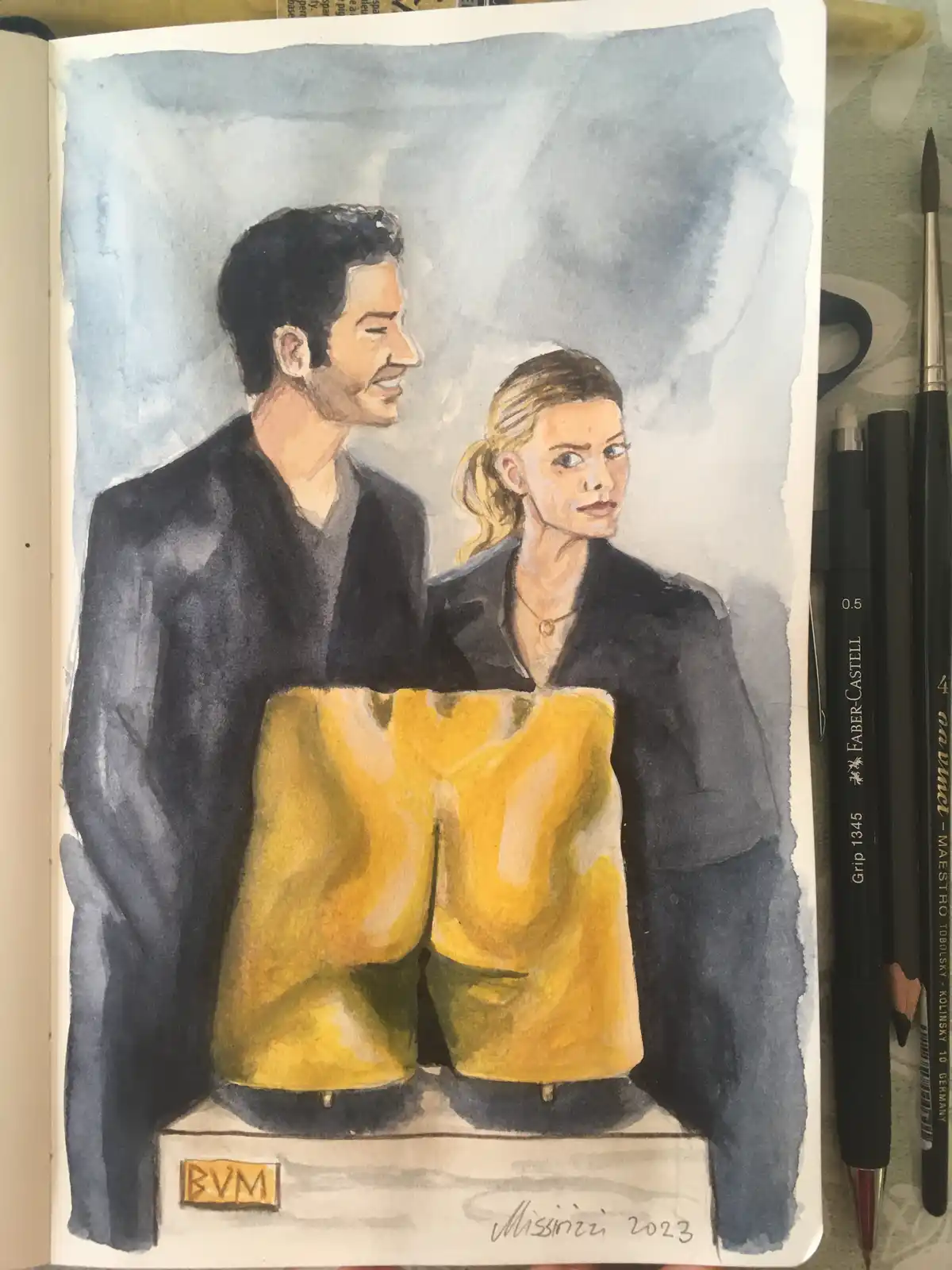 A watercolor sketch in a notebook depicts a man and a woman standing side-by-side, both wearing dark jackets, but their…