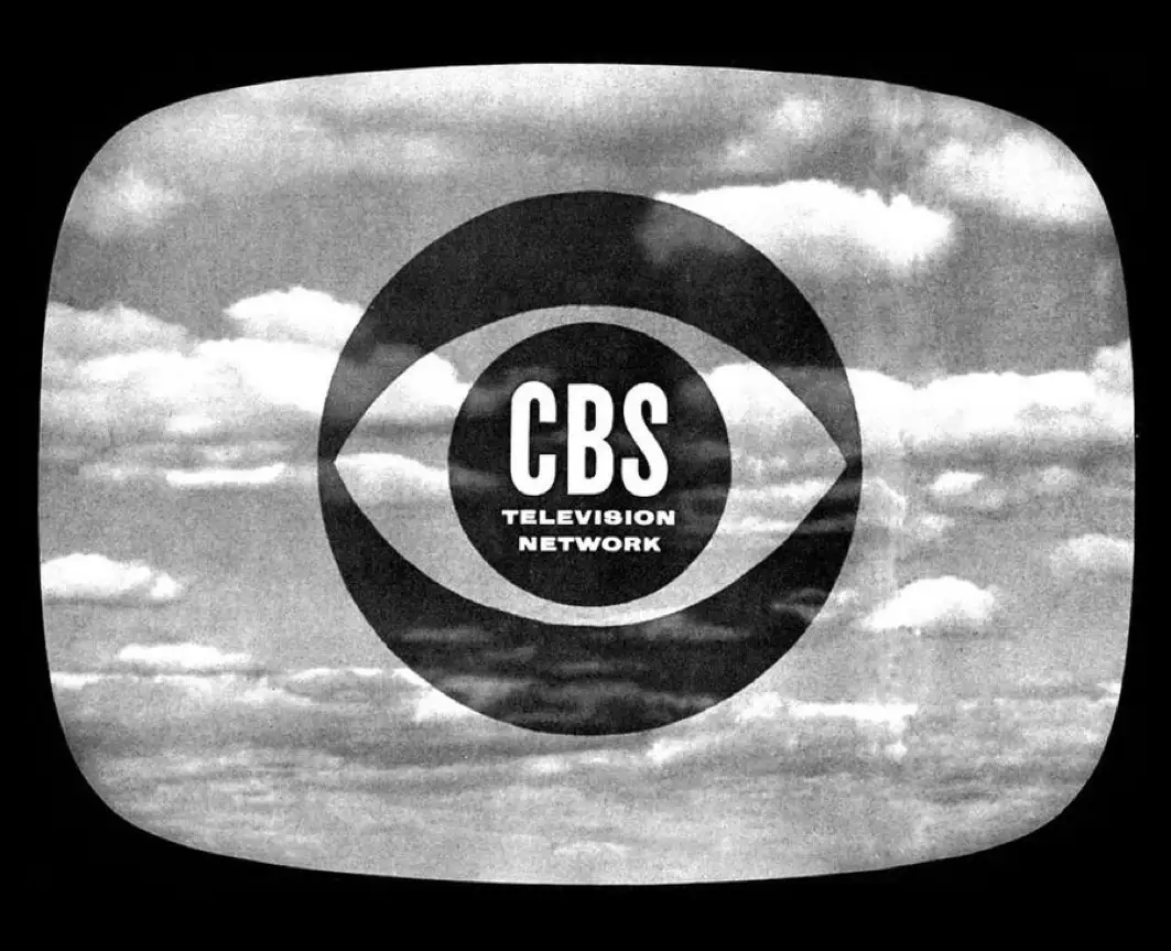 A black-and-white image of a vintage television screen displaying the CBS Television Network logo, which is an eye-shaped…