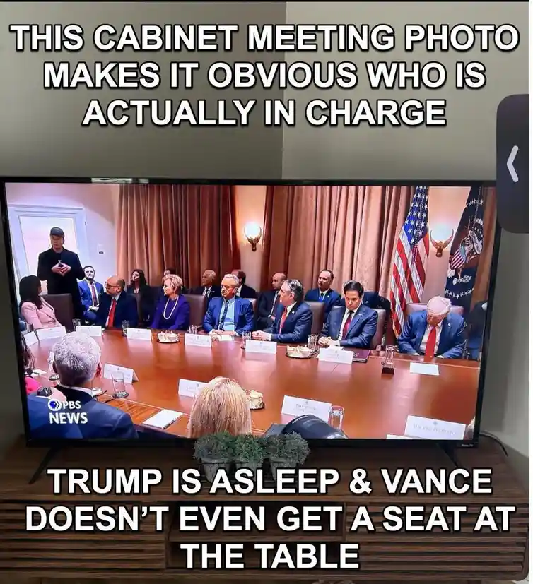 A photo of a television screen showing a cabinet meeting, with Donald Trump asleep at the table and JD Vance not seated. The…